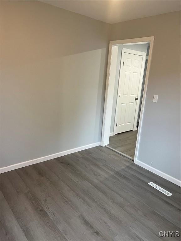 spare room with dark wood-type flooring