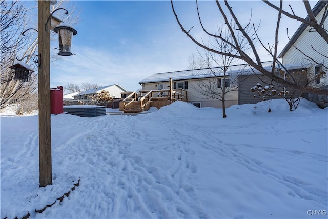 yard covered in snow featuring a deck