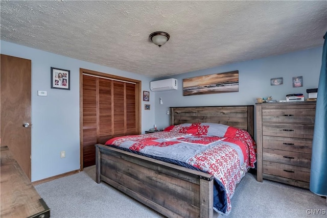 carpeted bedroom with a wall mounted air conditioner, a textured ceiling, and a closet