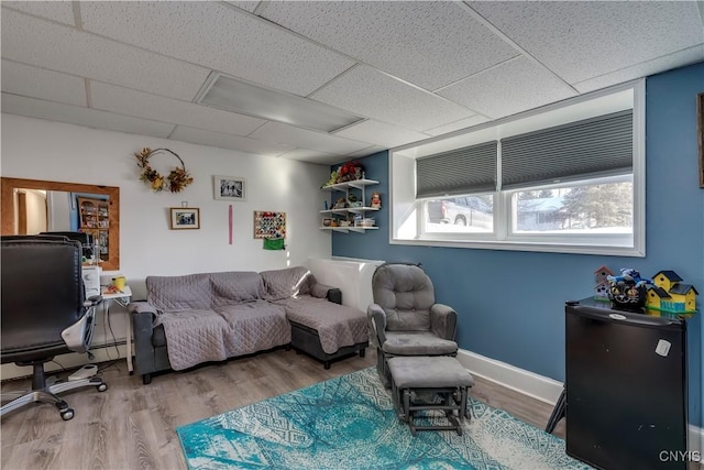 living room with a paneled ceiling and wood-type flooring