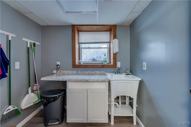 bathroom featuring a drop ceiling and wood-type flooring