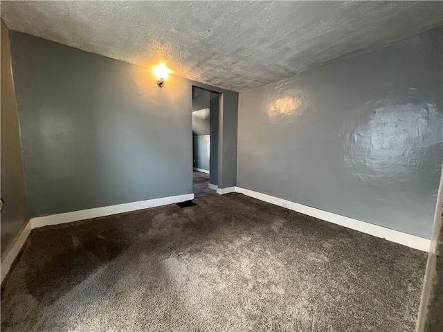 carpeted spare room with a textured ceiling