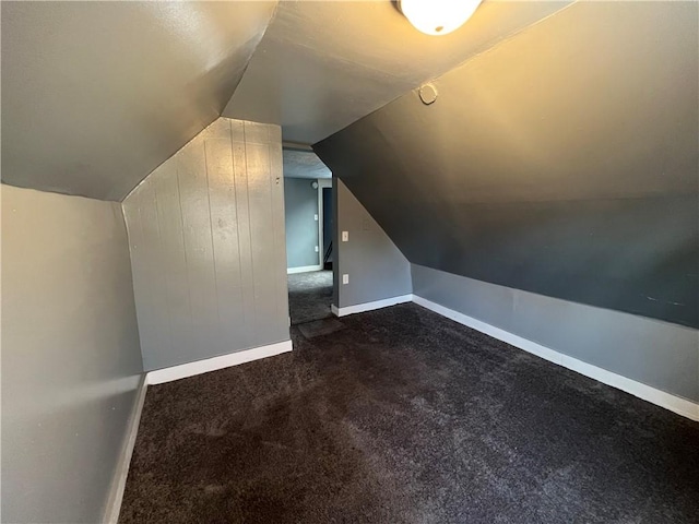 bonus room featuring dark carpet and vaulted ceiling