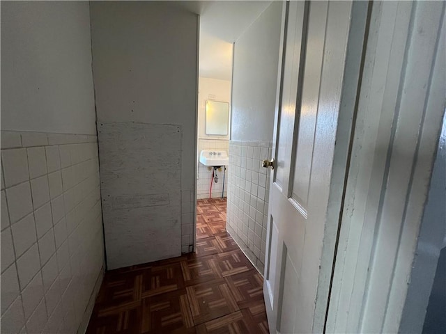 corridor featuring dark parquet floors and tile walls