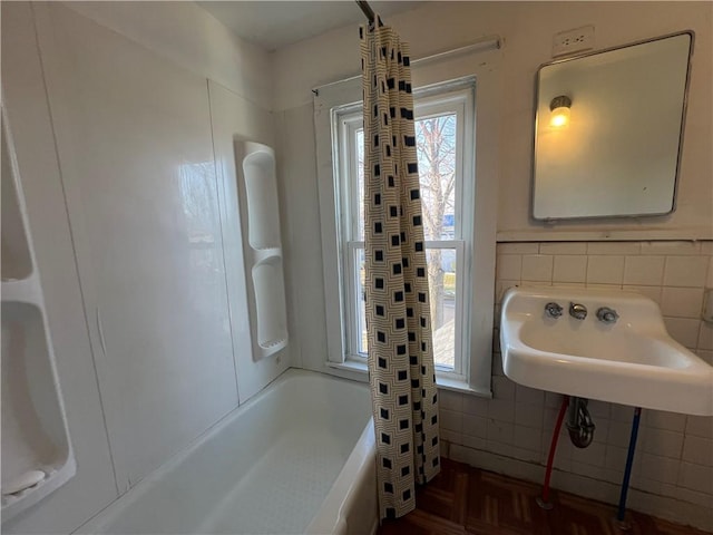 bathroom featuring tasteful backsplash, sink, and shower / tub combo with curtain