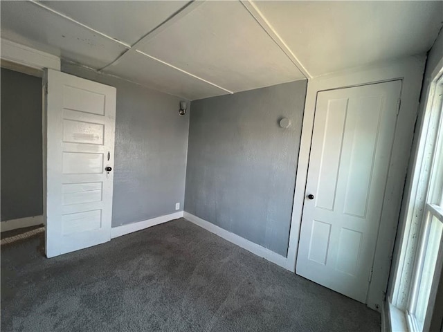 unfurnished room featuring dark carpet