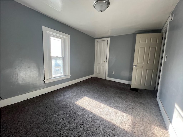 unfurnished bedroom with dark colored carpet