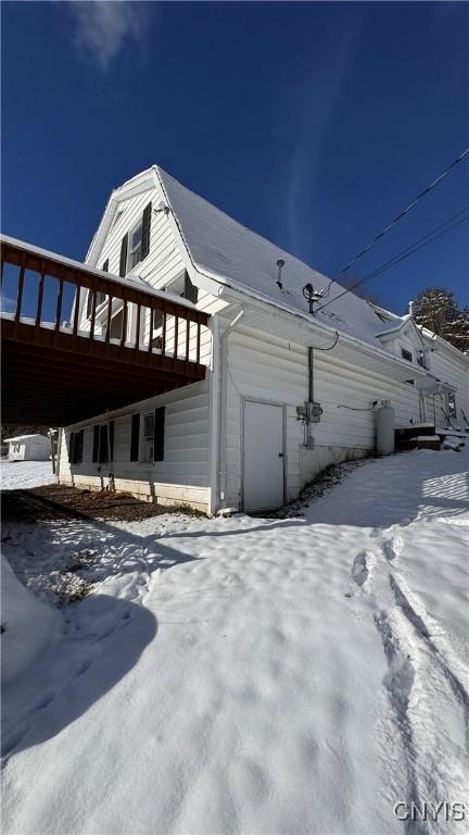 view of snow covered exterior featuring a wooden deck