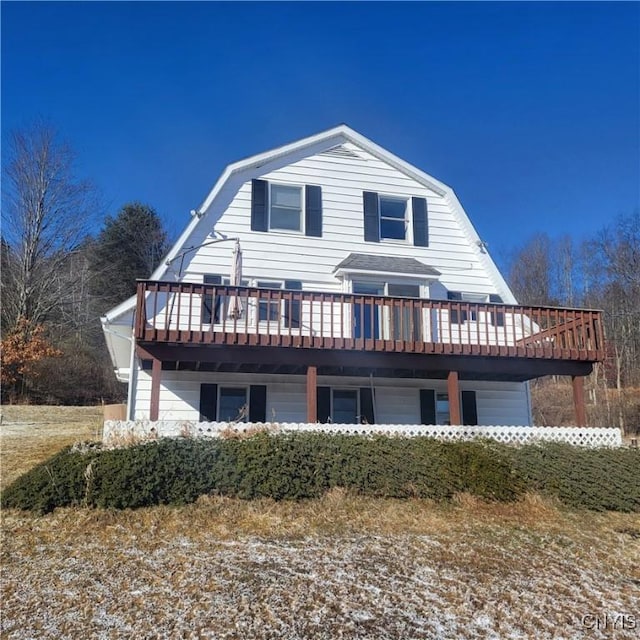 view of front of property featuring a deck and a gambrel roof