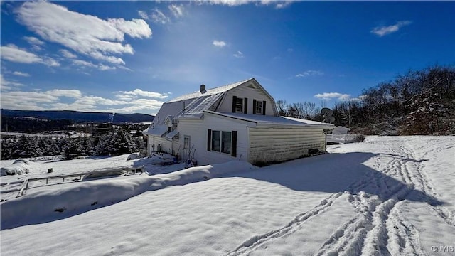 snow covered property featuring a gambrel roof