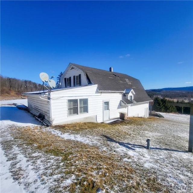 snow covered property featuring a gambrel roof