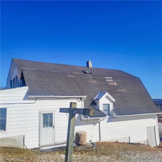 back of property featuring a shingled roof and a gambrel roof