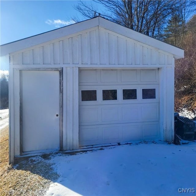 snow covered garage with a detached garage