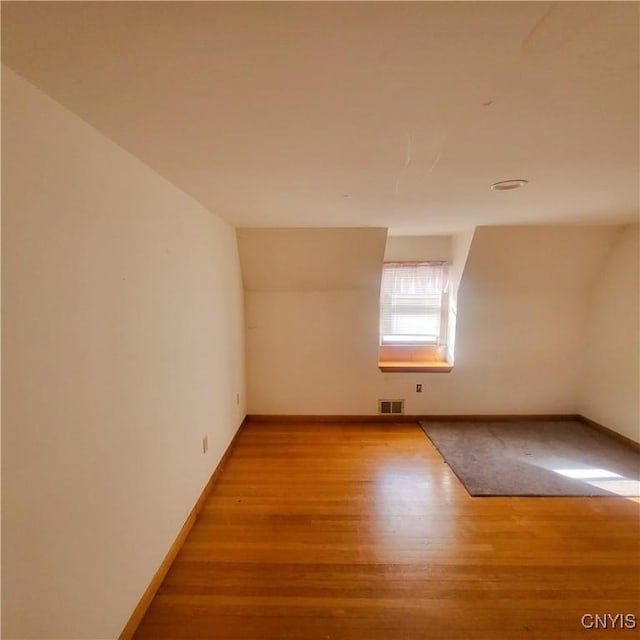 bonus room with visible vents, baseboards, and wood finished floors