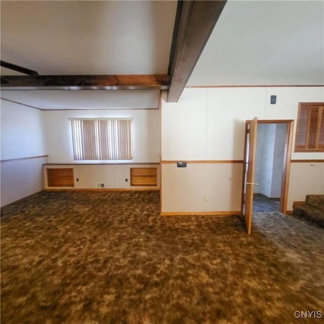 unfurnished room featuring carpet floors and beamed ceiling