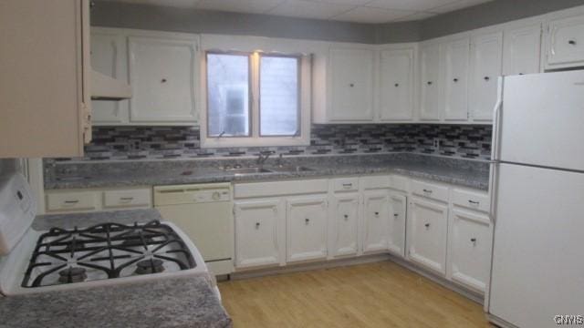 kitchen with tasteful backsplash, white appliances, sink, light hardwood / wood-style floors, and white cabinetry