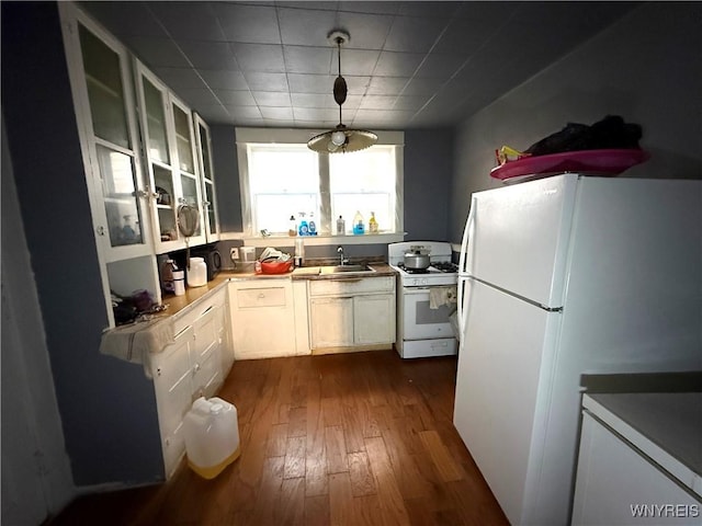 kitchen with white appliances, sink, decorative light fixtures, dark hardwood / wood-style flooring, and white cabinetry