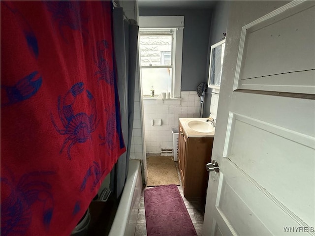 bathroom with shower / bath combination with curtain, vanity, and tile walls