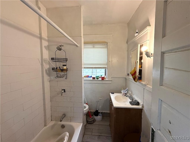 full bathroom with toilet, vanity, and tiled shower / bath combo