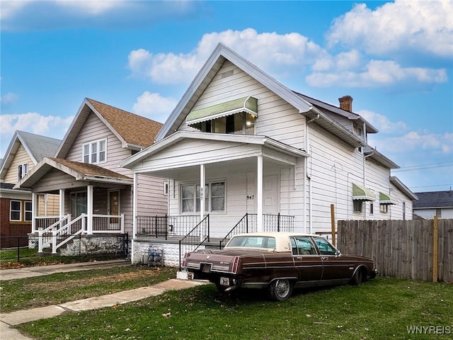 view of front of house with covered porch and a front lawn