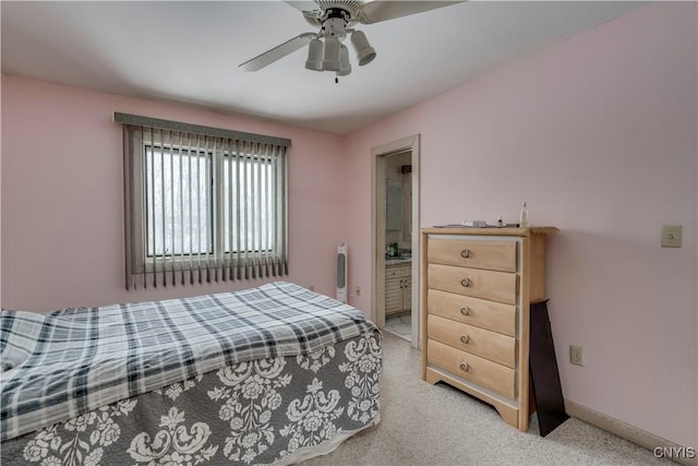 carpeted bedroom with ensuite bath and ceiling fan