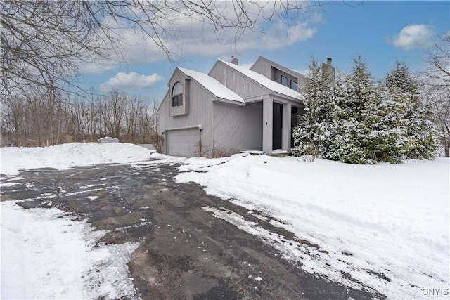 view of snow covered exterior featuring a garage