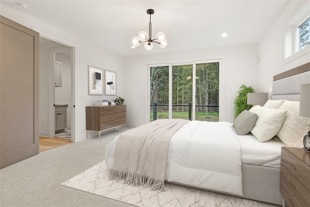 carpeted bedroom with ensuite bathroom and an inviting chandelier