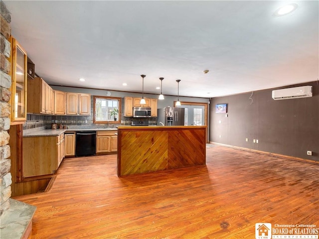 kitchen with stainless steel appliances, tasteful backsplash, an AC wall unit, pendant lighting, and light wood-type flooring