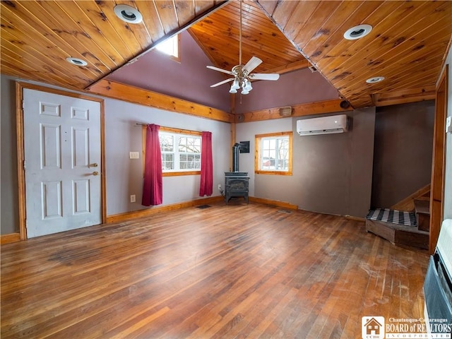 unfurnished living room featuring wooden ceiling, a wood stove, hardwood / wood-style flooring, ceiling fan, and a wall mounted AC