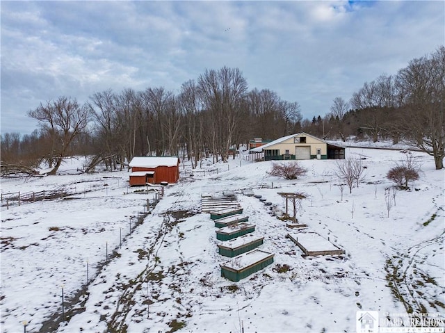 snowy yard featuring an outbuilding