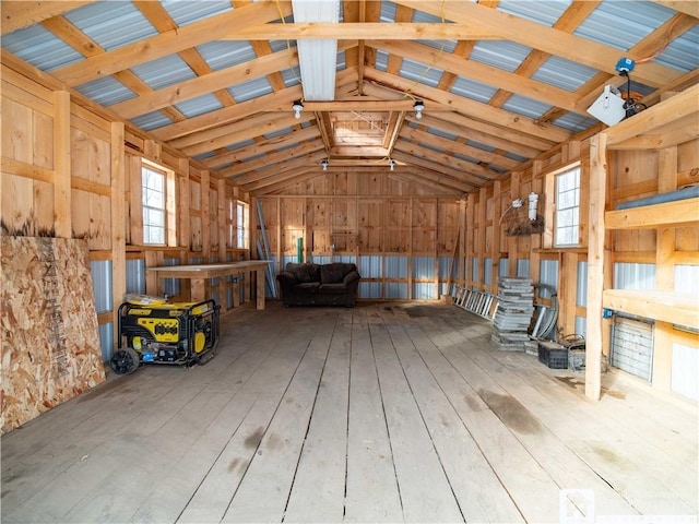 misc room with wood walls, high vaulted ceiling, and light hardwood / wood-style flooring