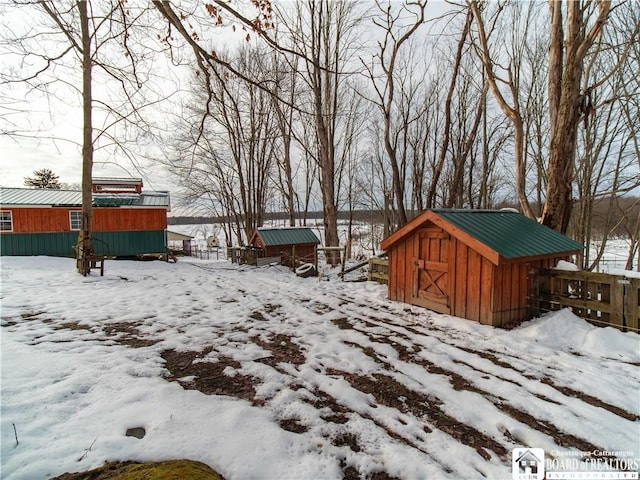 yard covered in snow featuring a storage unit