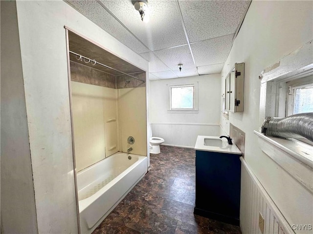 full bathroom with a paneled ceiling, vanity, bathtub / shower combination, and toilet