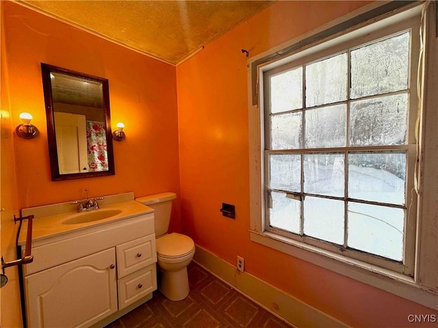 bathroom with vanity, toilet, and a wealth of natural light