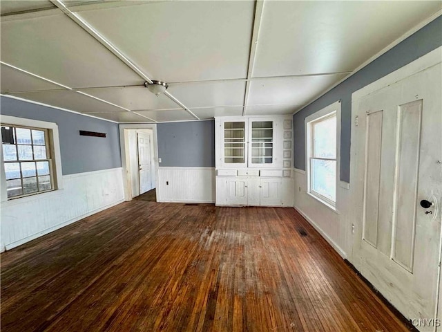 unfurnished room with plenty of natural light and dark wood-type flooring