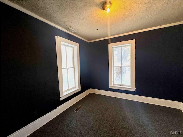 unfurnished room featuring a textured ceiling and ornamental molding