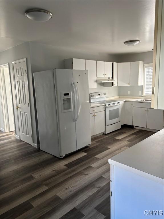 kitchen featuring white cabinetry, dark hardwood / wood-style floors, and white appliances