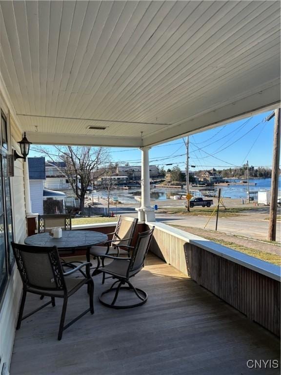 wooden deck featuring covered porch and a water view