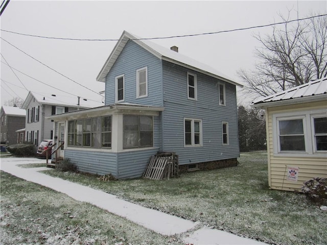 exterior space featuring a yard and a sunroom