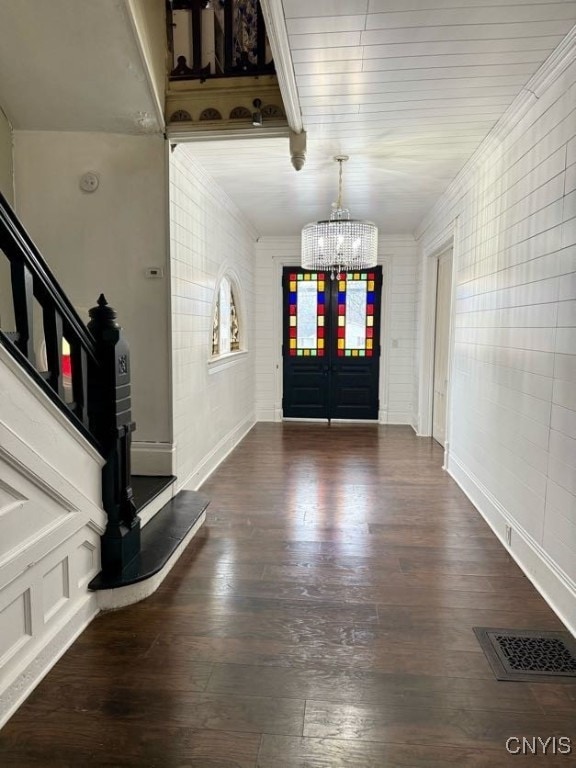 entrance foyer featuring french doors, dark wood-type flooring, and an inviting chandelier