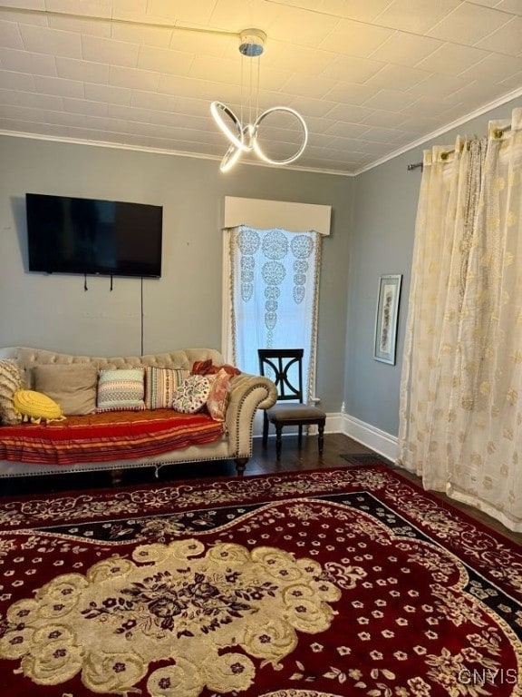 living room featuring crown molding, hardwood / wood-style floors, and a notable chandelier