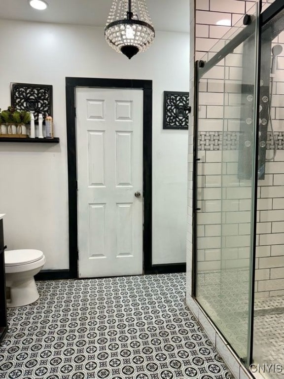 bathroom with tile patterned flooring, vanity, toilet, and a shower with door