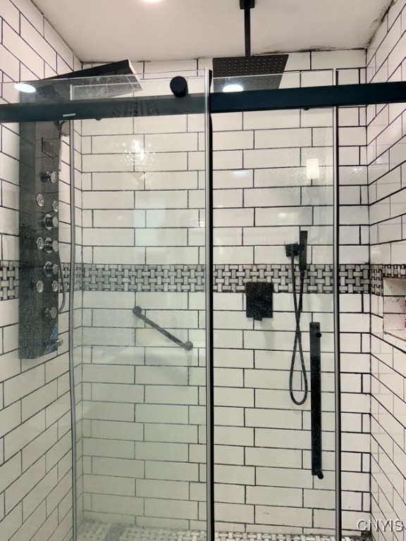 interior details featuring a shower with shower door