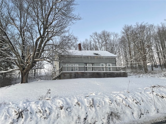 snow covered property featuring a chimney