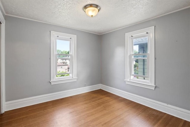 unfurnished room with hardwood / wood-style floors and a textured ceiling