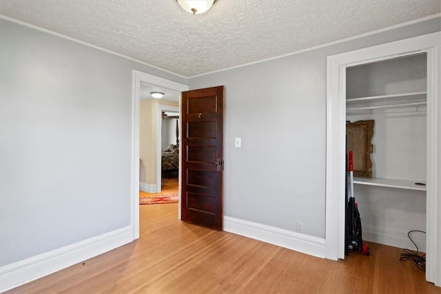 unfurnished bedroom featuring a textured ceiling, hardwood / wood-style flooring, and a closet