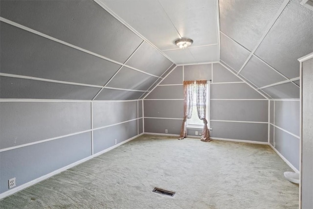 additional living space with carpet flooring and lofted ceiling