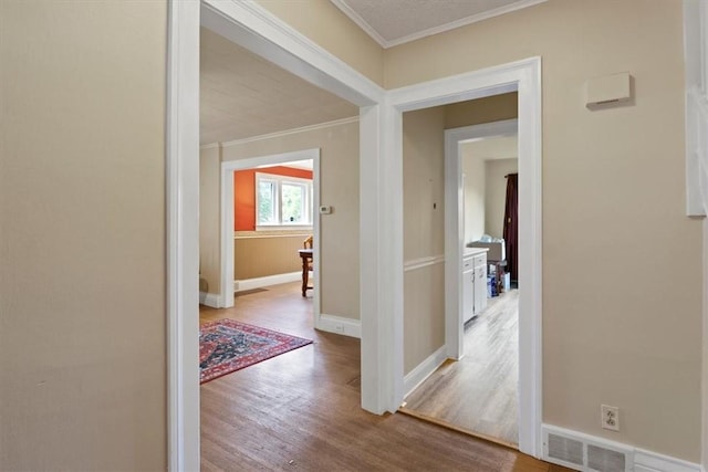 hall featuring wood-type flooring and ornamental molding