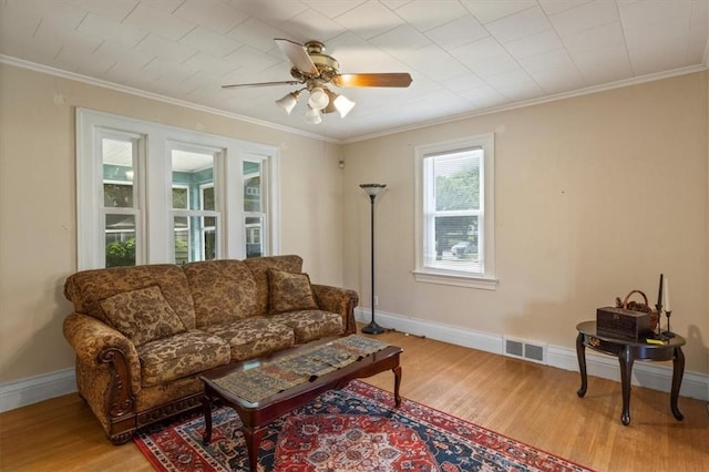 living room featuring light hardwood / wood-style floors, ceiling fan, and ornamental molding