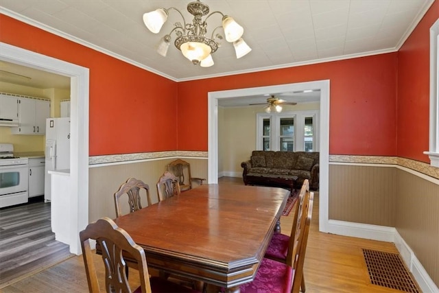 dining room featuring ornamental molding, ceiling fan with notable chandelier, and hardwood / wood-style flooring